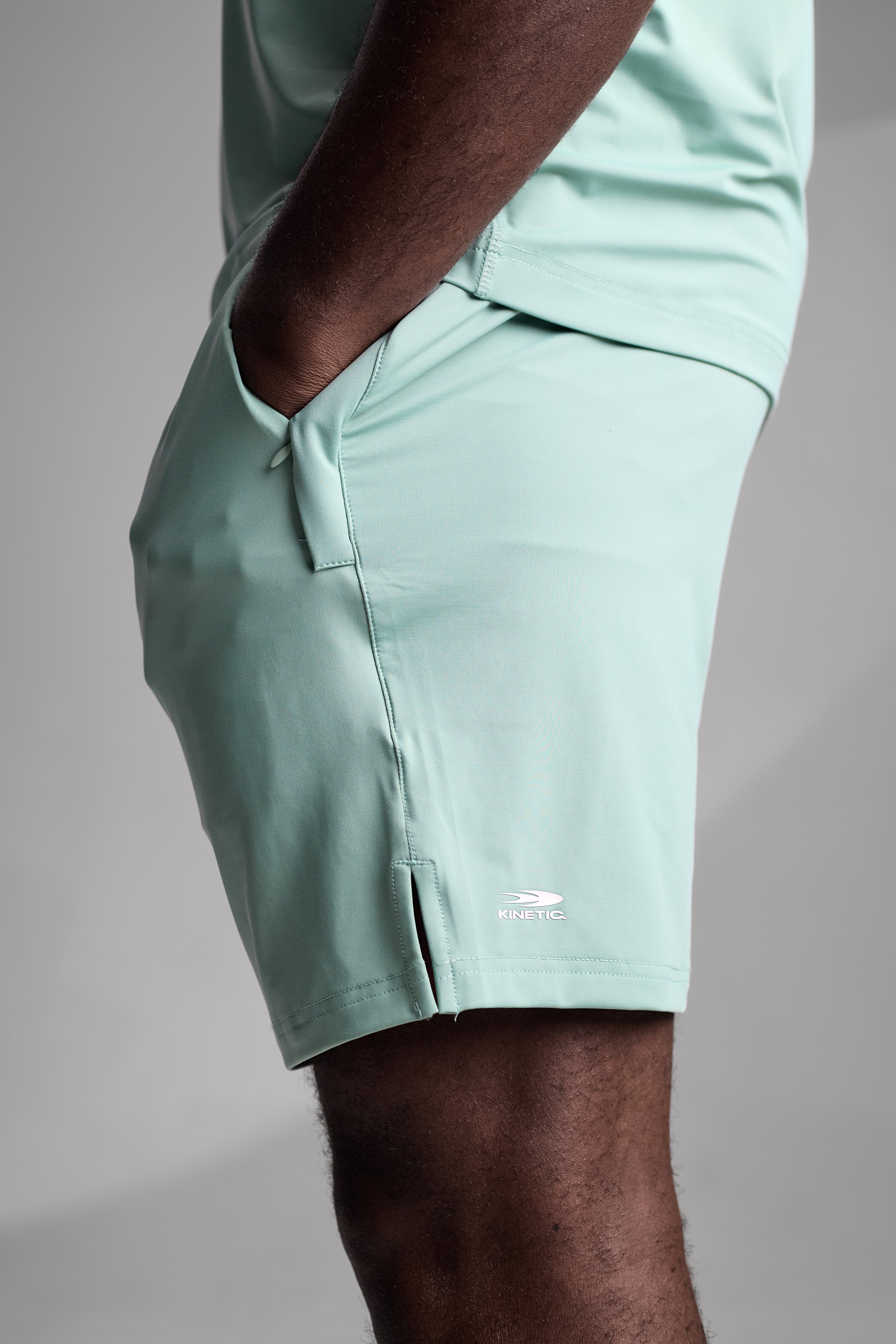 Light green shorts worn by a person on a gray background