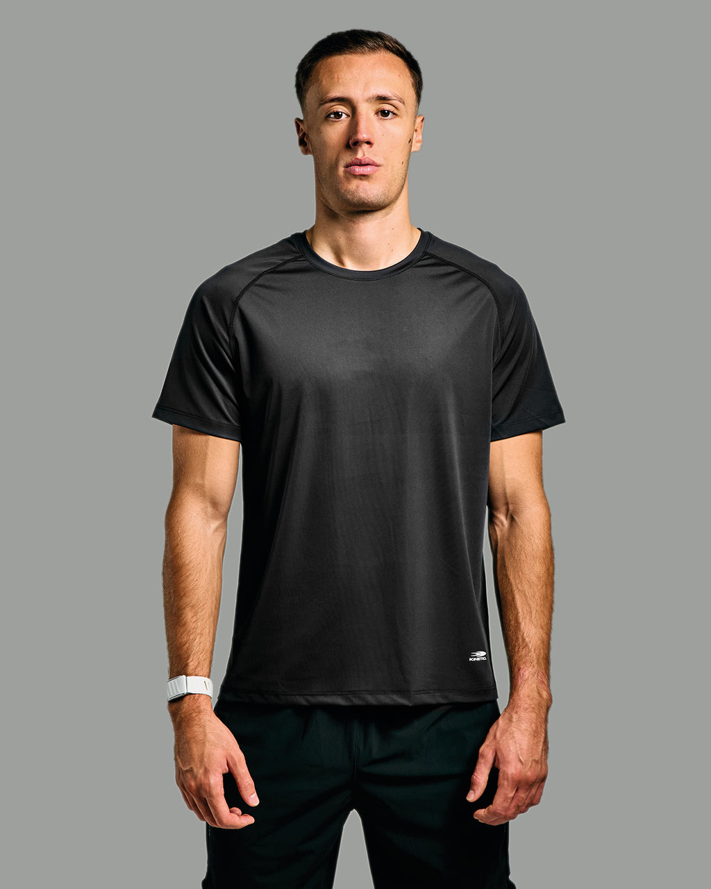 Man wearing a black athletic shirt on a gray background