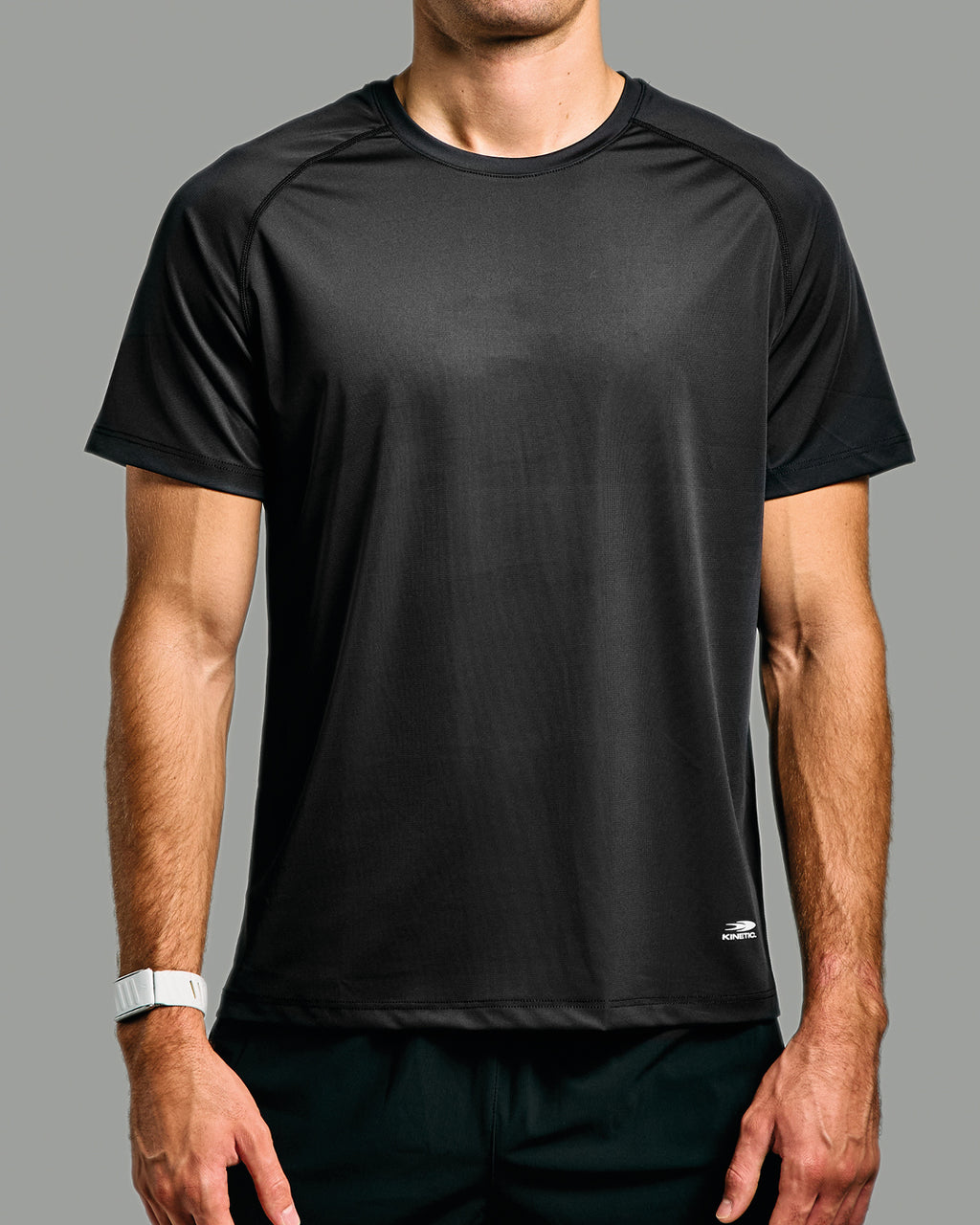 Black athletic shirt worn by a person on a gray background