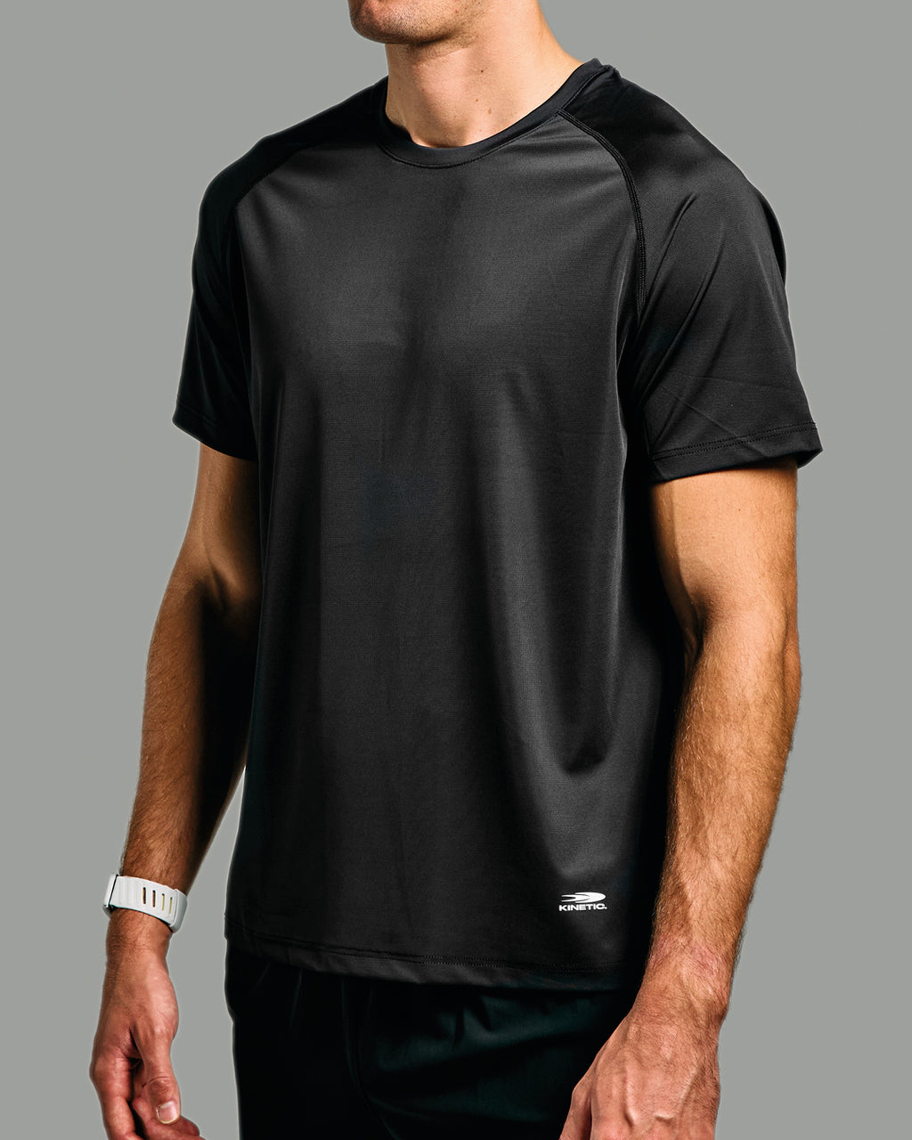 Black athletic shirt worn by a person on a gray background