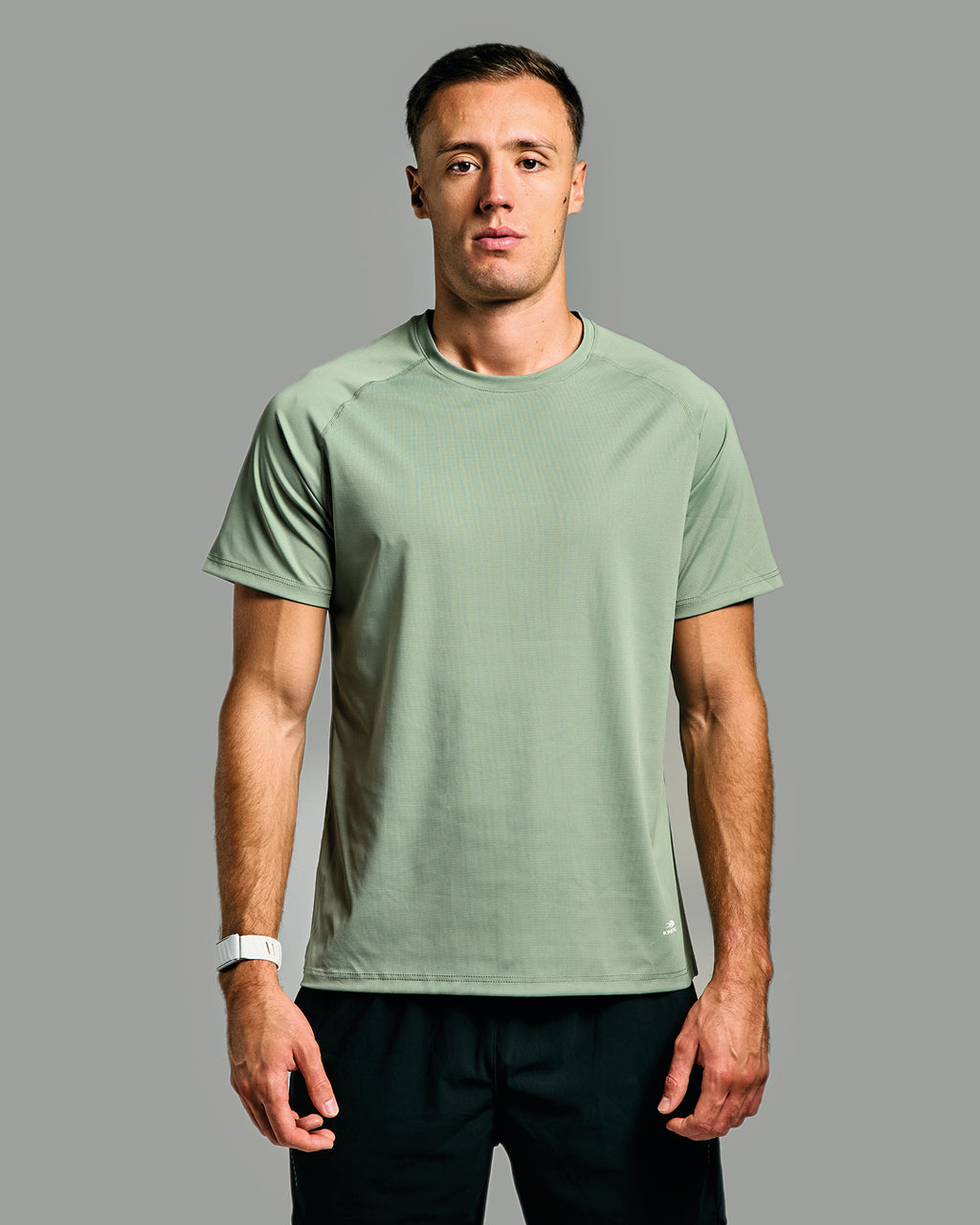 Man wearing a green athletic shirt against a gray background