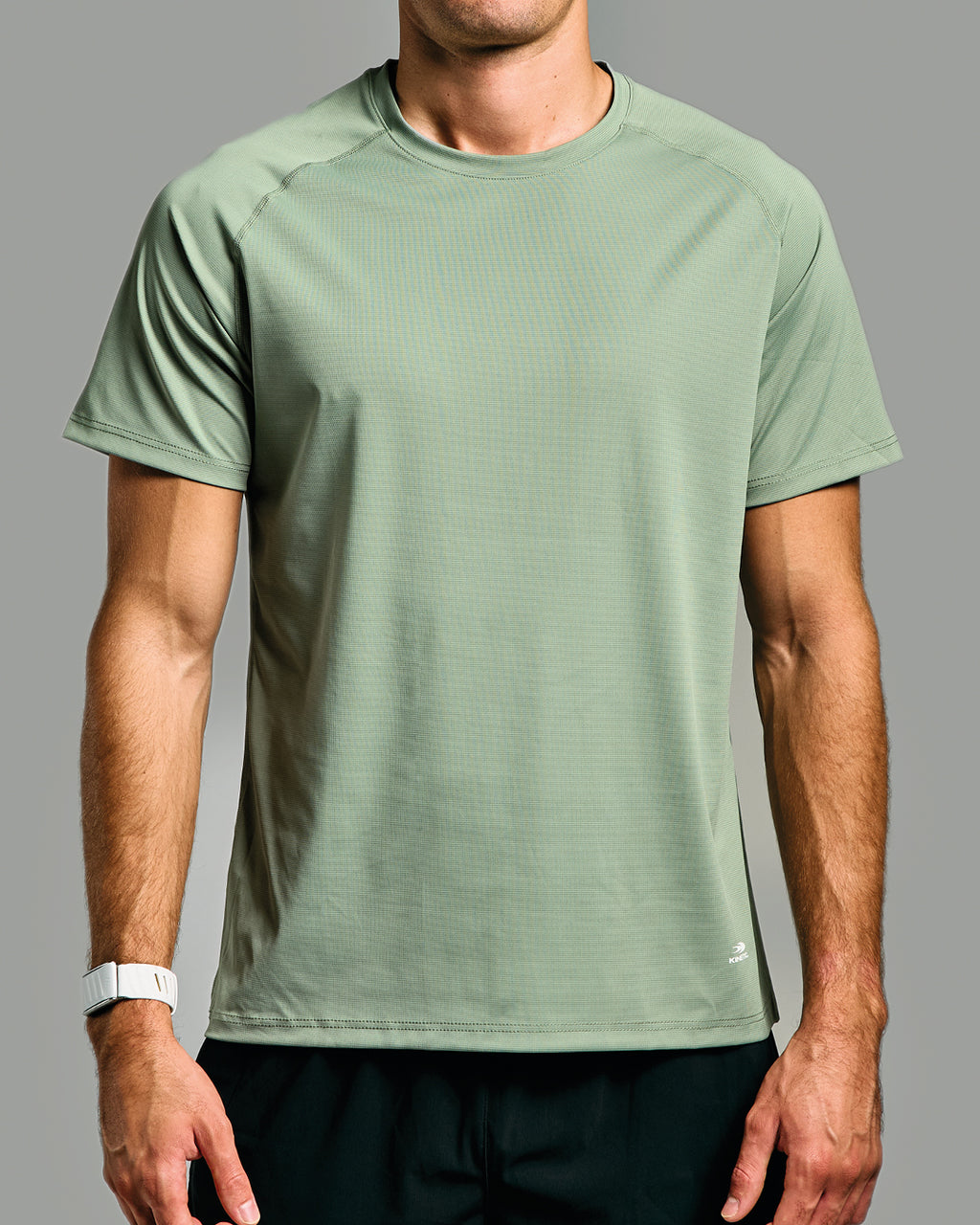 Person wearing a green athletic shirt on a gray background