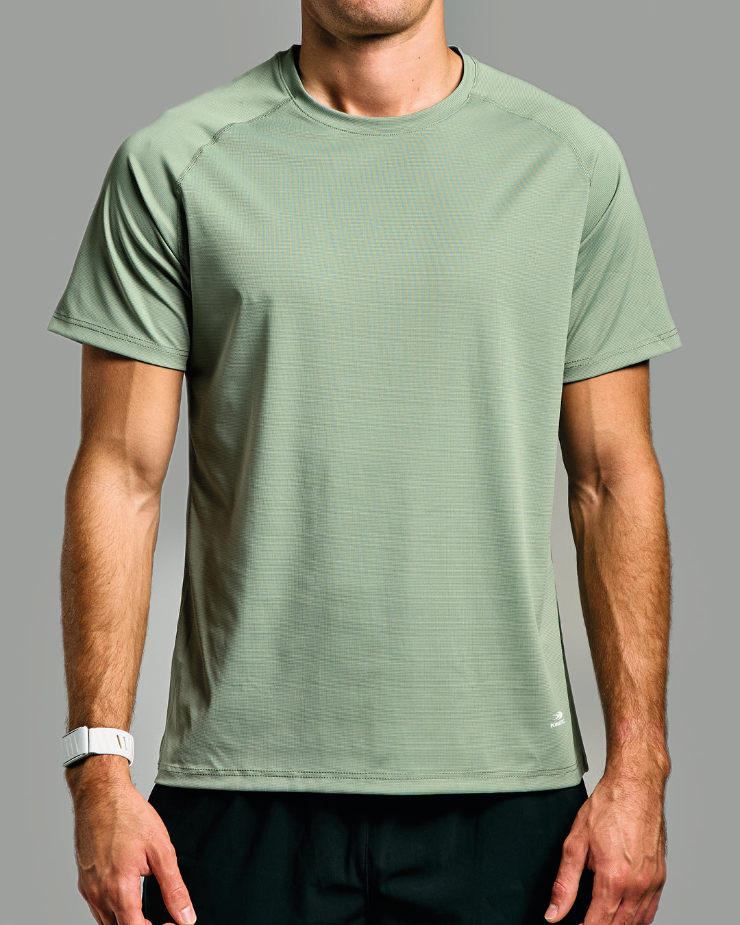 Person wearing a green athletic shirt on a gray background