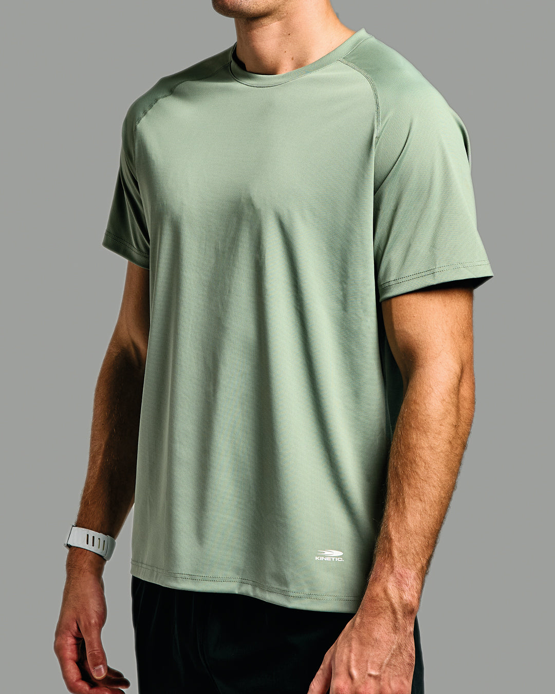 Person wearing a green athletic shirt on a gray background