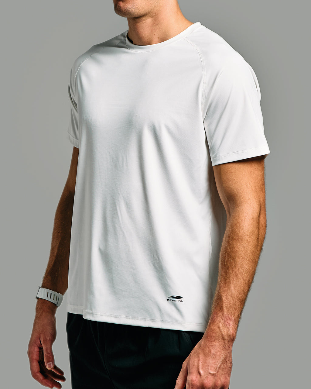 Person wearing a plain white t-shirt on a gray background