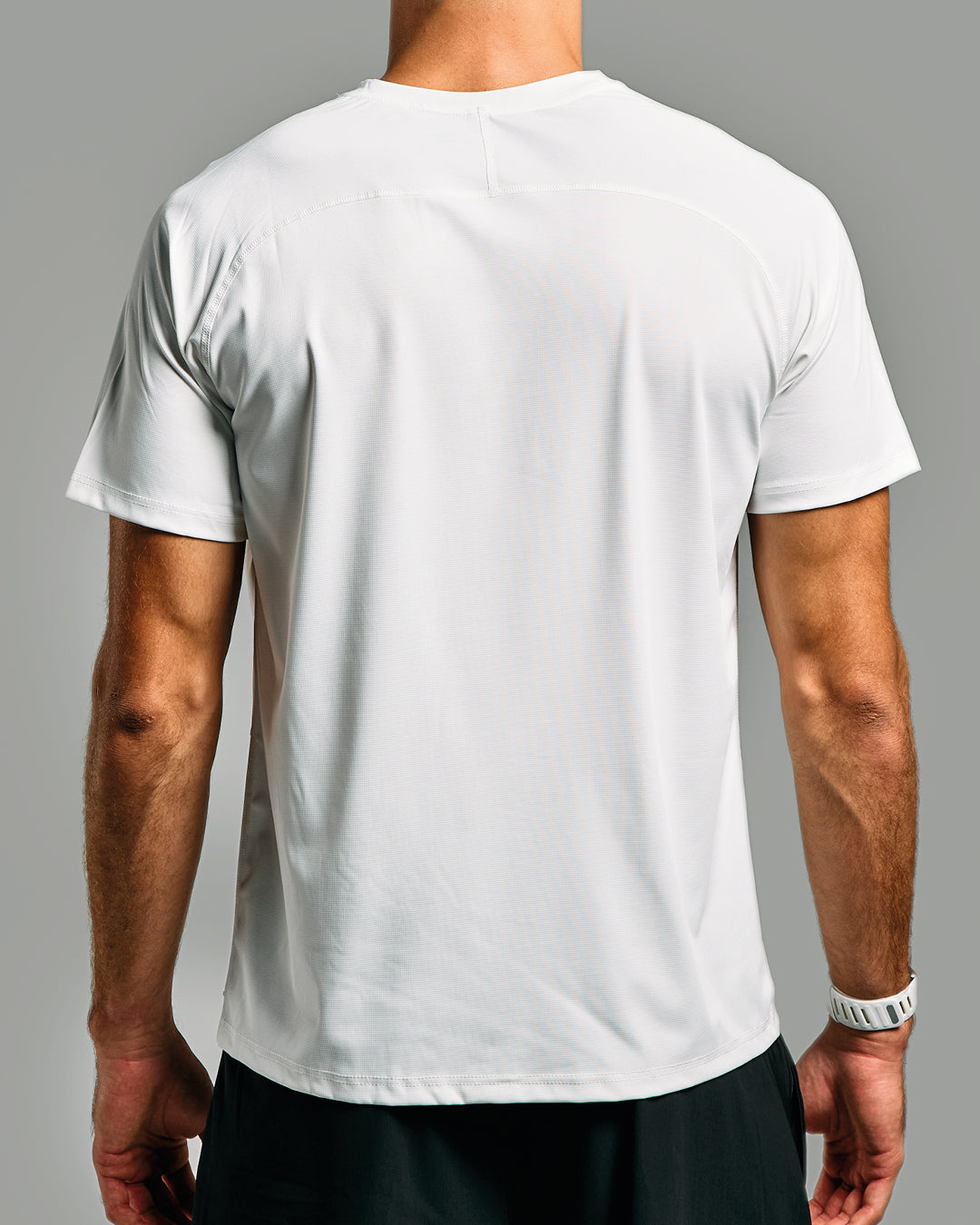 White t-shirt worn by a person on a gray background