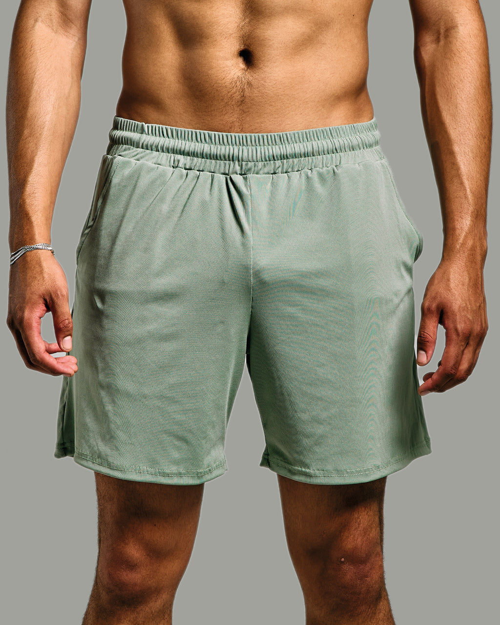 Person wearing green shorts on a gray background