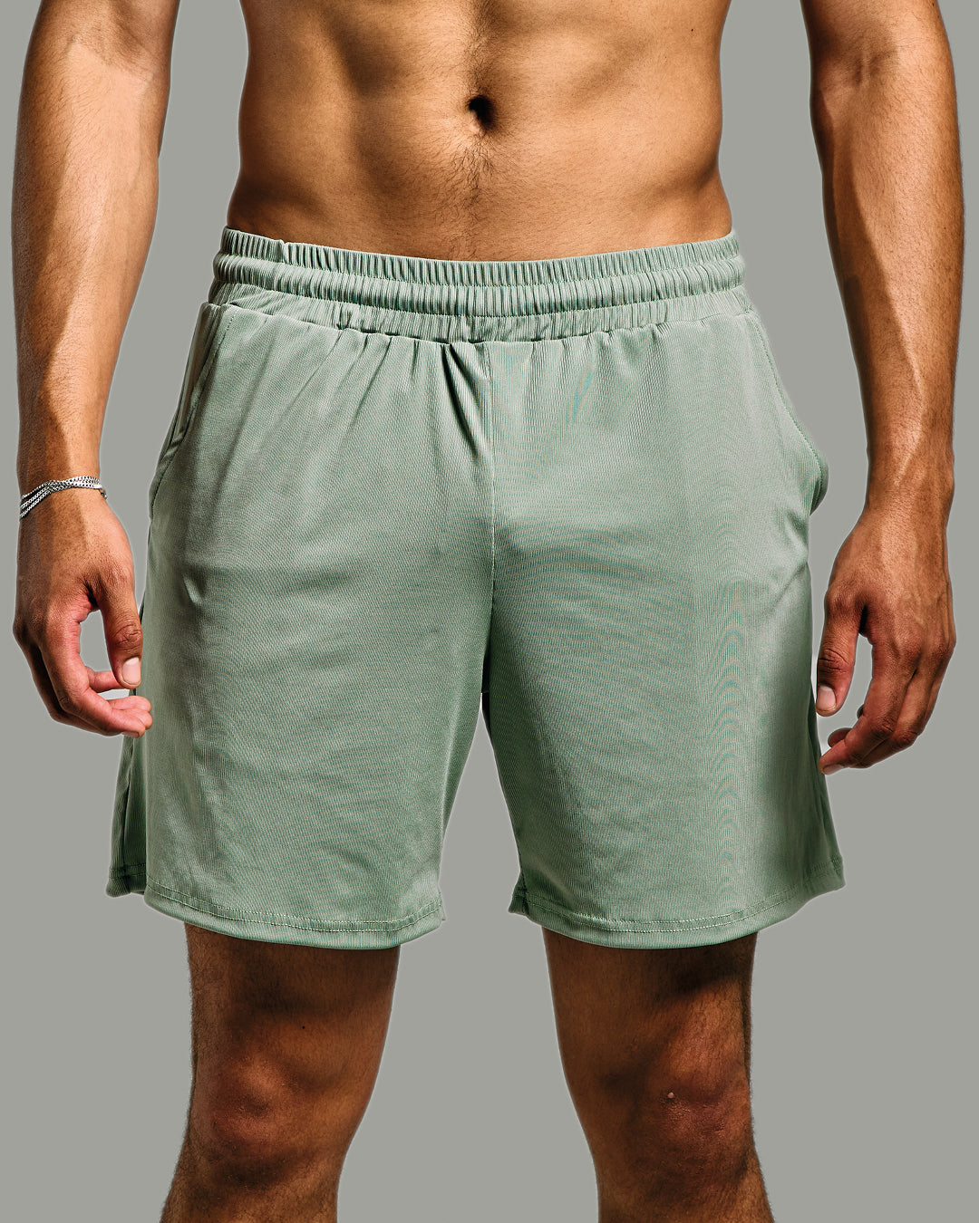 Person wearing green shorts on a gray background